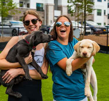 Women holding dogs